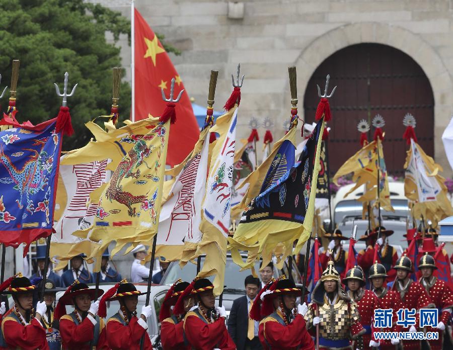 7月3日，韓國(guó)總統(tǒng)樸槿惠在青瓦臺(tái)總統(tǒng)府舉行隆重儀式，歡迎中國(guó)國(guó)家主席習(xí)近平對(duì)韓國(guó)進(jìn)行國(guó)事訪問(wèn)。這是習(xí)近平的車隊(duì)在身著民族服裝的韓國(guó)禮儀隊(duì)伍引導(dǎo)下駛?cè)肭嗤吲_(tái)。新華社記者丁林?jǐn)z  